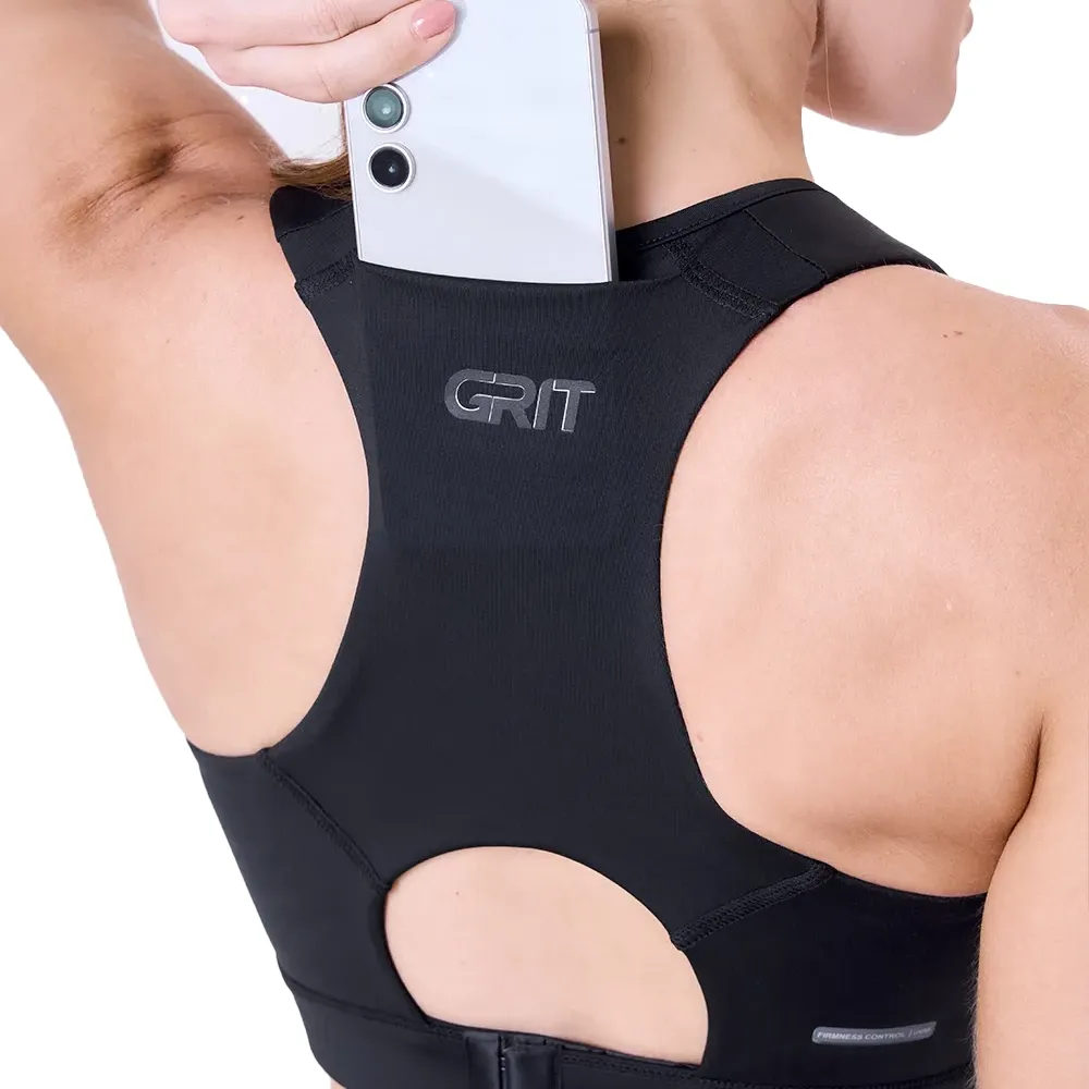 Top esportivo feminino preto com recortes nas costas e bolsos laterais, logo GRIT nas costas
